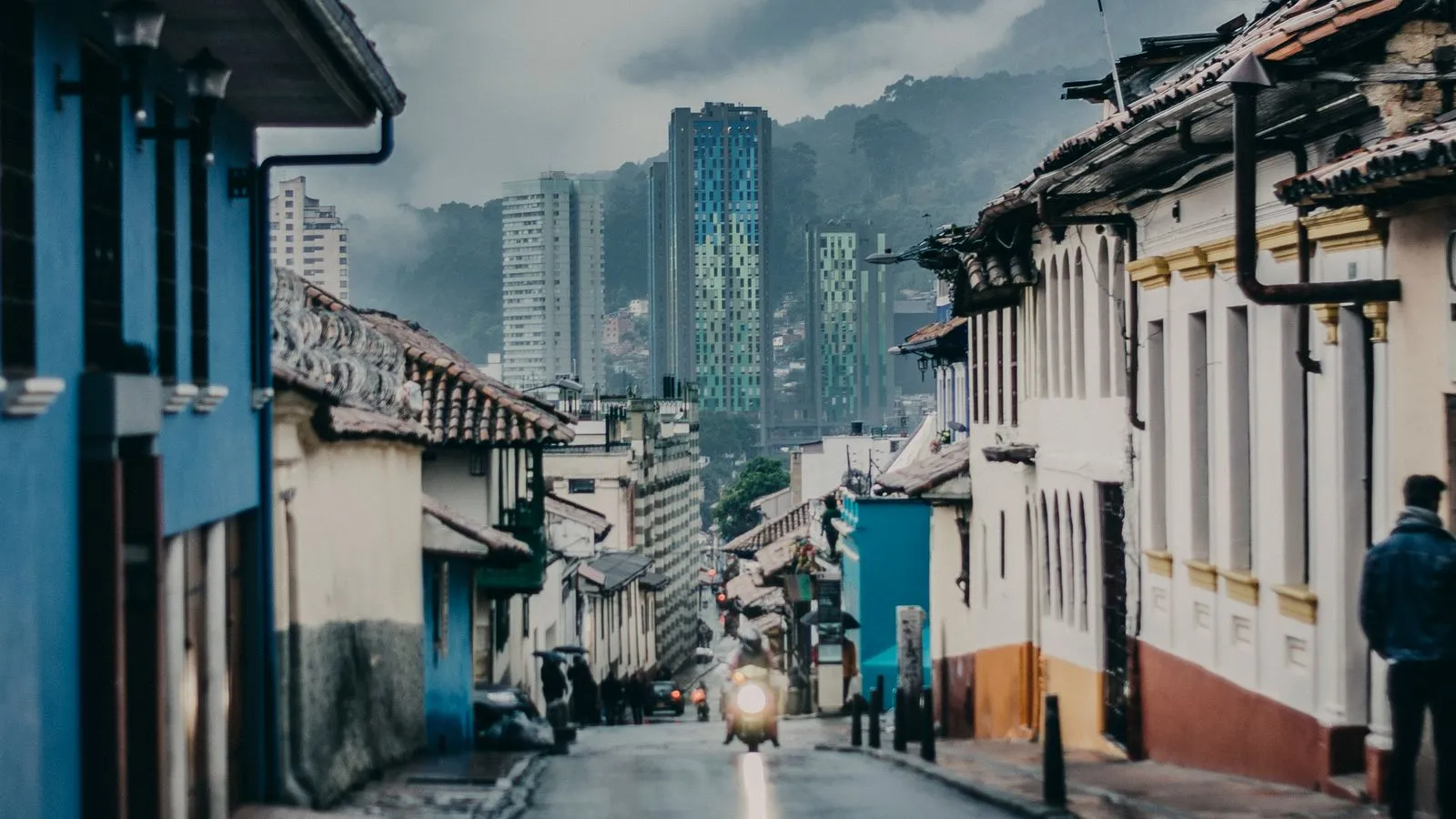 Una calle de Bogotá con casas de colores y rascacielos
