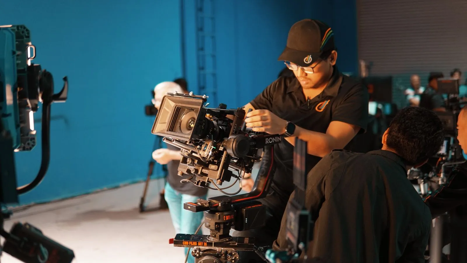 Equipo de filmación preparando cámaras en un estudio