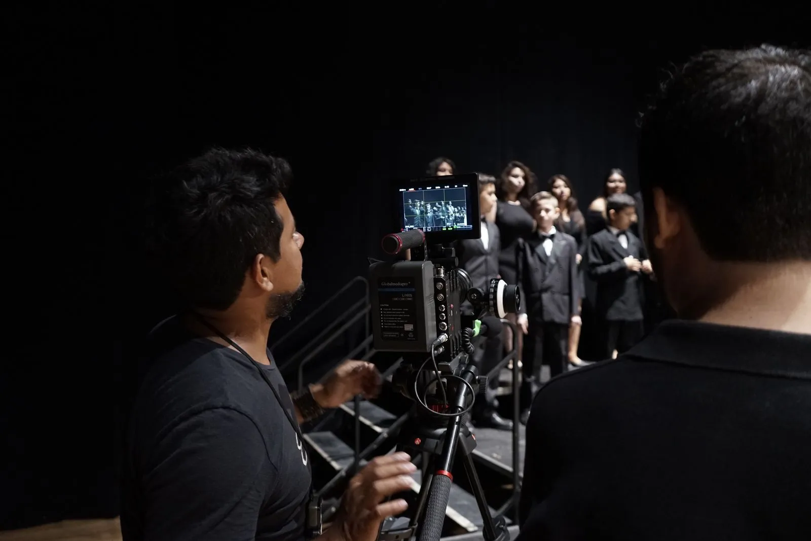 Camarógrafo filmando a un coro de chicos