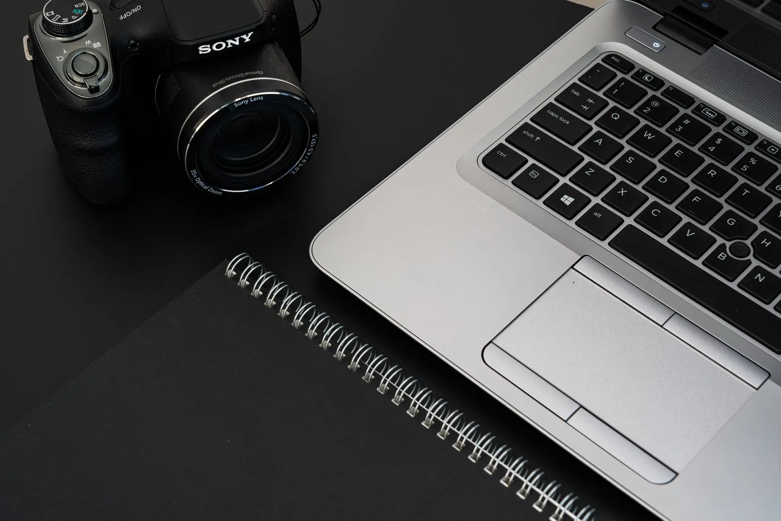 Escritorio con computadora, cámara y cuaderno