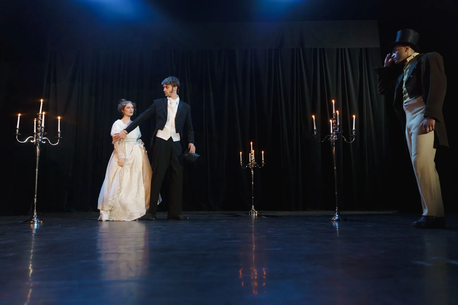 Escena de época iluminada con velas sobre un escenario