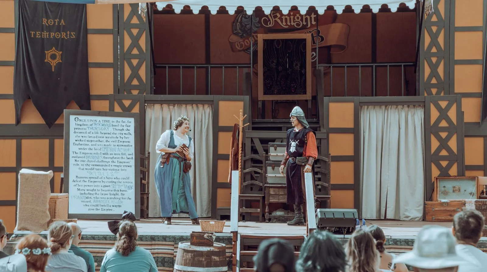 Actores con vestuario medieval actuando en un escenario al aire libre
