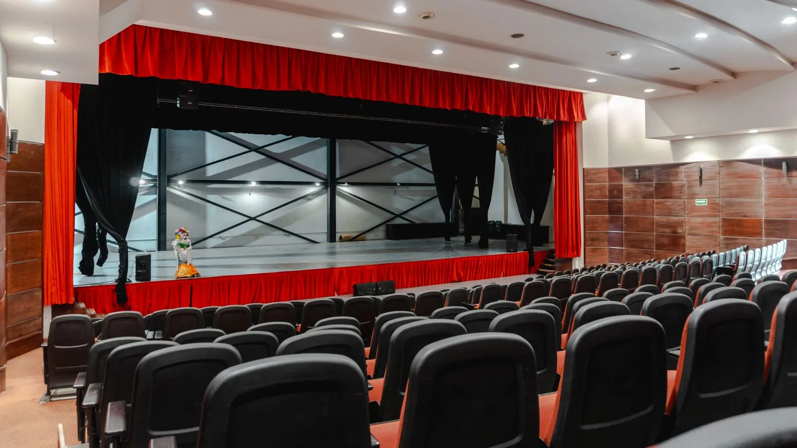 Sala de teatro con telón rojo antes de la función