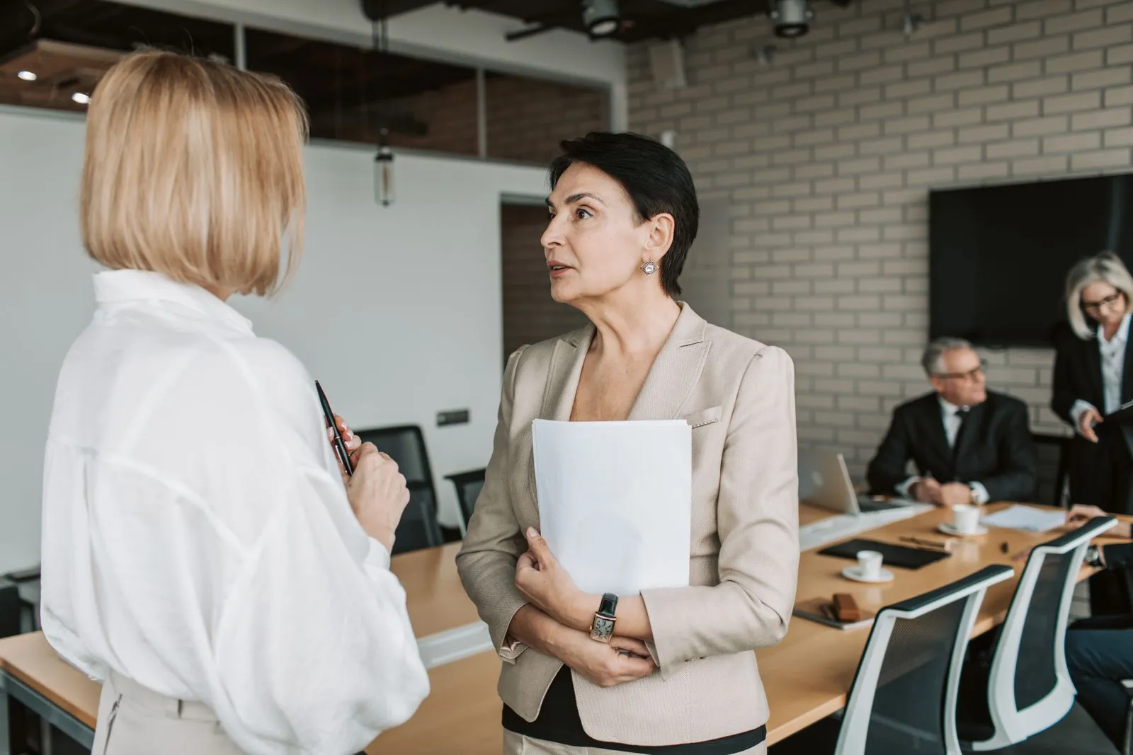 Dos mujeres conversando en una reunión de trabajo