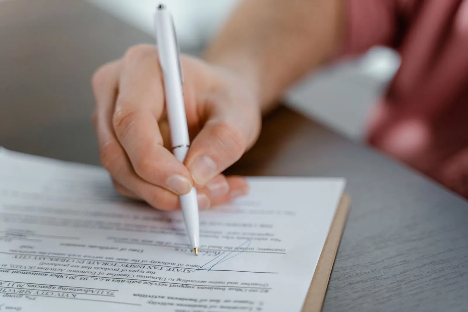 Una mano firmando un contrato